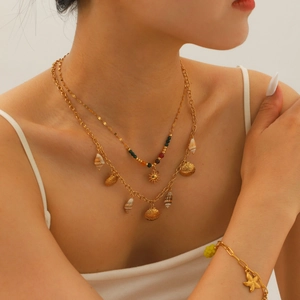 Boho layered gold necklace and bracelet set with sea shells and starfish pendants