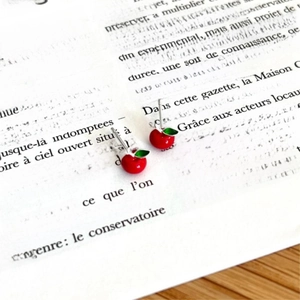 Minimalist 925 sterling silver red cherry stud earrings on a vintage French book page