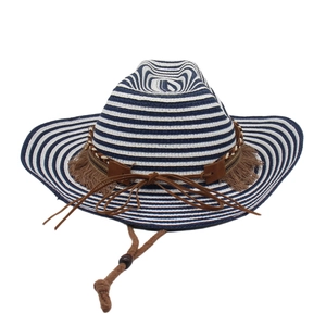 Detail of blue striped straw cowboy hat with woven brown band and adjustable chin strap