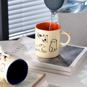 Cute cream ceramic coffee mugs featuring cartoon dog and cat illustrations for couples
