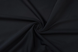 Gros plan sur la texture du tissu sportif noir respirant avec détails de plis doux