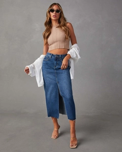 Dettaglio di gonna lunga in denim blu scuro con spacco alto e orlo con frange