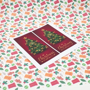 Deep red Christmas cards with golden tree design on a festive background of holiday patterns