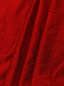 Macro shot of red knit fabric texture showing soft folds and detailed weave for men's suit