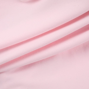 Close-up of the smooth pink textile fabric showing fine texture and soft draping quality