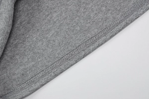 Detailed macro view of double-needle stitching on grey knit fabric hem and texture