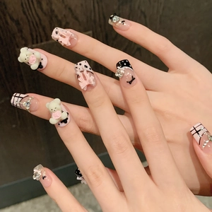 Detail of pink and white handmade press-on nails with 3D bears and crystal accents