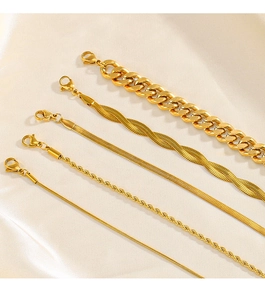 Detail of five 18K gold plated stainless steel layered chain bracelets on satin fabric