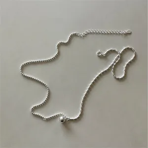 Macro view of a 925 silver beaded necklace chain with a spherical pendant on leather