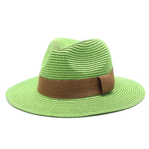 Detail of bright green woven straw fedora hat with contrast brown fabric ribbon band