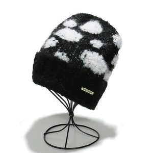 Winter knitted beanie with cloud pattern and gold metal label on a black knit base