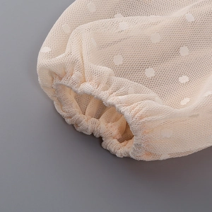 Macro shot of apricot hollow out lace dress showing polka dot mesh cuffs and elastic sleeves
