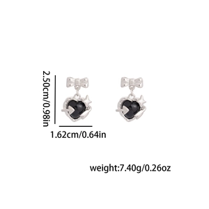 Détail de boucles d'oreilles cœur argenté avec nœud et flèche avec dimensions