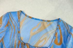 Détail de l'encolure en U sur robe en maille tie-dye avec imprimé marbre bleu et orange