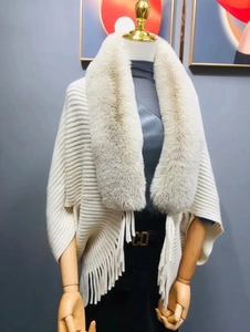 Detail of elegant knit shawl featuring premium faux fur collar and long fringe trim