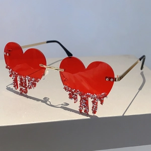 Detail of red heart sunglasses featuring rhinestone droplets and gold metal temples