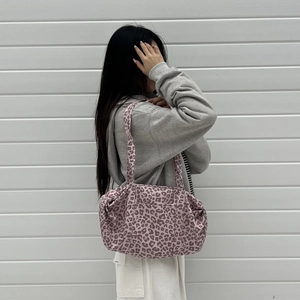 Dettaglio di una borsa tote grande con stampa leopardata rosa, tasca frontale e manico