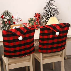 Christmas chair covers in red and black buffalo plaid pattern with white pom pom tassels