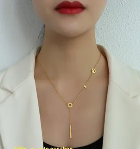 Close-up of 18k gold plated Y-necklace with LOVE letters and pendant on a model