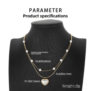 Close-up of double-layered stainless steel necklace with white pearls and heart pendant