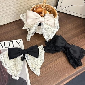 Detailed view of layered lace bow hair clips in cream, monochrome, and black tones