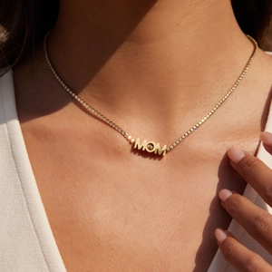 Nahaufnahme der goldenen MOM-Halskette mit Zirkonia-Tennis-Kette an einem Model