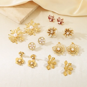 Set of seven gold earrings with pearls, coral elements and white flower petals on silk