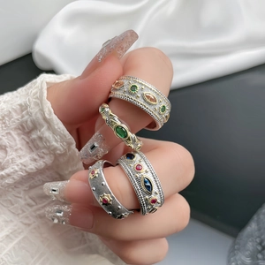 Detailed close-up of bohemian style ring set with vintage lace carvings and colorful gems