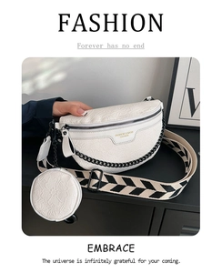 Detail of white embossed floral leather chest bag with black chain and woven strap