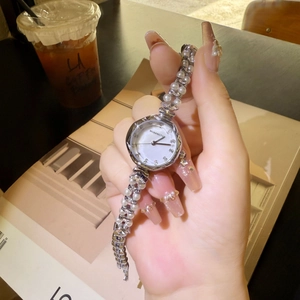 Detail of silver quartz watch featuring mother of pearl dial and pearl bracelet strap