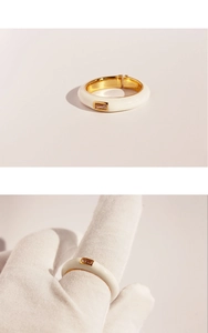Detail of white enamel ring with champagne rectangle zircon and golden inner band