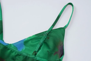 Dettaglio della tracolla regolabile e del tessuto satinato stampato verde del top