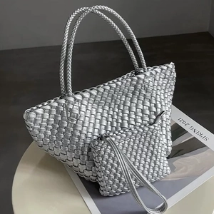 Macro detail of silver woven tote set with metallic texture and matching pouch