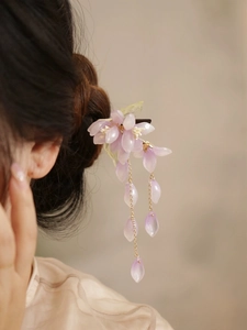 Detailansicht der lila Blüten-Haarnadel mit goldenen Quasten an eleganter Frisur
