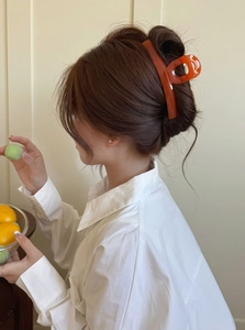 Side view of large amber orange translucent hair claw clip on model's head