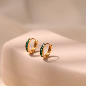 Detailed side view of 18K gold plated hoop earrings with emerald green cubic zirconia