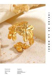 Gros plan d'une bague florale dorée avec des motifs de fleurs à cinq pétales