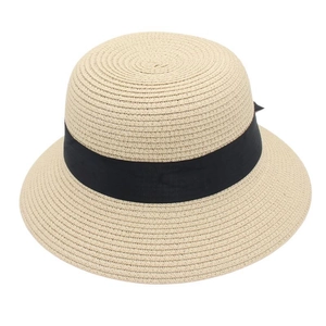 Close-up of beige straw sun hat featuring a classic black ribbon bow and fine weave