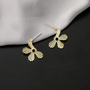 Detailed macro view of gold flower earrings with radial texture and S925 silver needle hallmark
