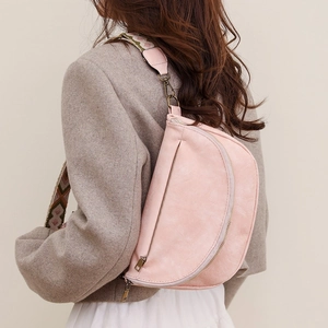 Detail of pink crescent waist bag with geometric pattern wide strap and vintage hardware