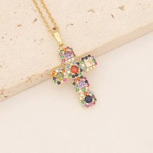 Gold-plated cross necklace with colorful micro-pave cubic zirconia on stone background