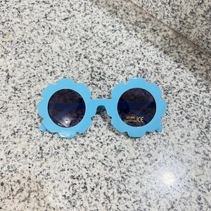 Detail of blue flower-shaped kids sunglasses with UV400 protection and CE mark