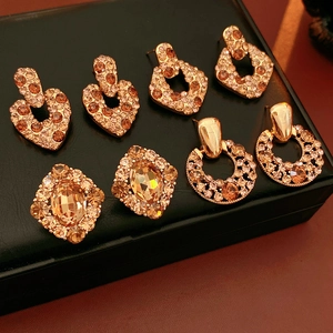 Vue macro de boucles d'oreilles vintage en or avec zircons champagne sur cuir noir
