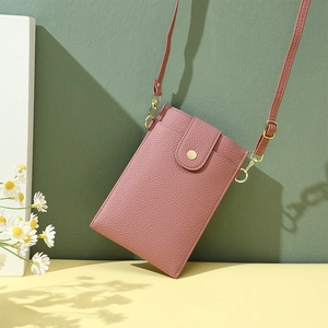 Detailaufnahme der rosa PU-Ledertextur und goldener Metallschnalle der kleinen Handtasche