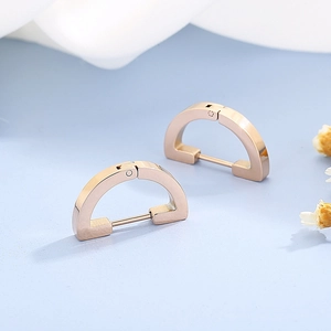 Minimalist D-shaped rose gold geometric hoop earrings on light blue background