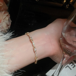 Detailed close-up of a gold-plated bracelet with zircon hearts and round crystals on wrist