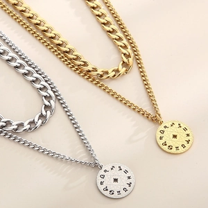 Detail of gold and silver layered necklaces with zodiac coin pendants and chunky chains