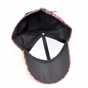 Detail view of ethnic style baseball cap featuring woven fabric and adjustable leather strap