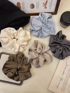 Close-up of oversized satin scrunchies in five Morandi colors with silk texture finish