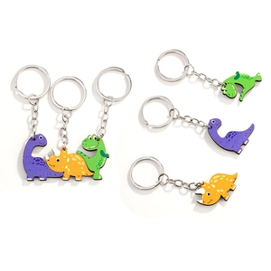Three cute wooden cartoon dinosaur keychains with metal rings on white background
